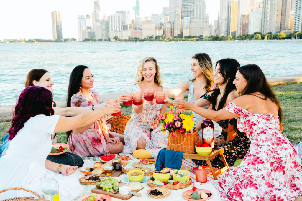 KSP03862 "Cheers" with kombucha, women raise their glasses at a picnic on Chicago's lakeshore